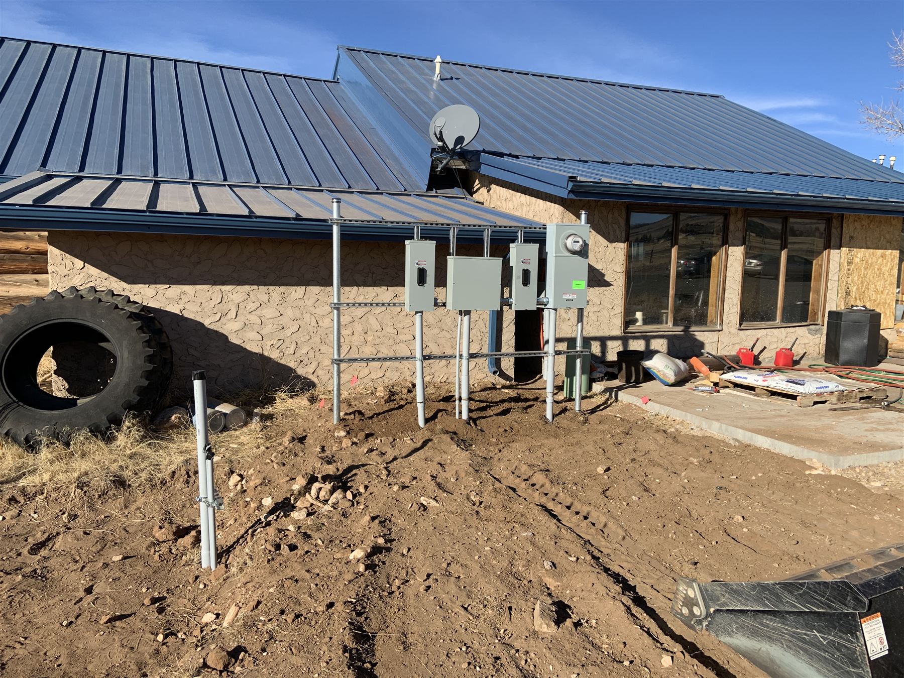 Multiple new electrical panels mounted on the exterior of a home